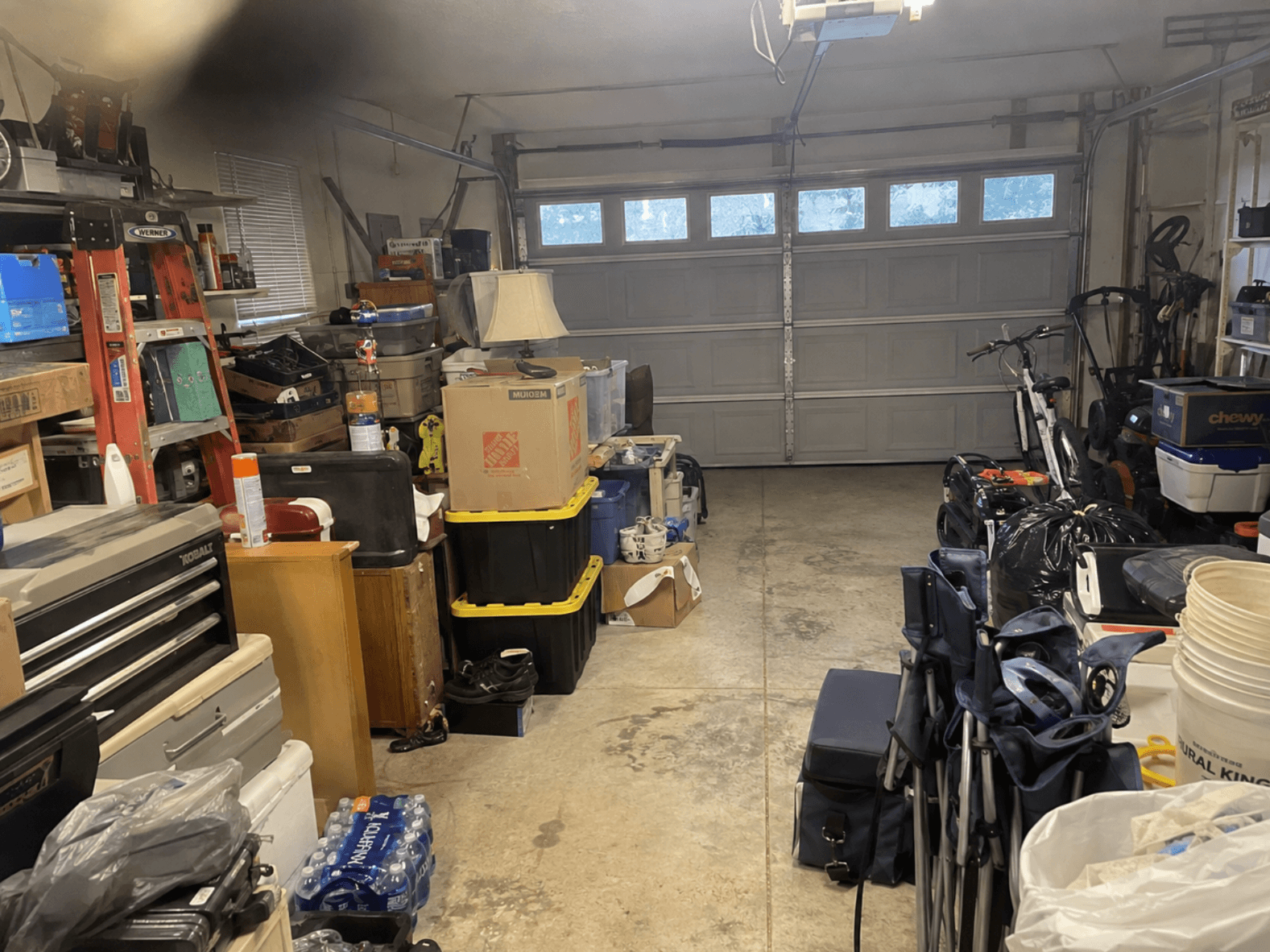 A garage packed with boxes, tools, bikes and storage bins