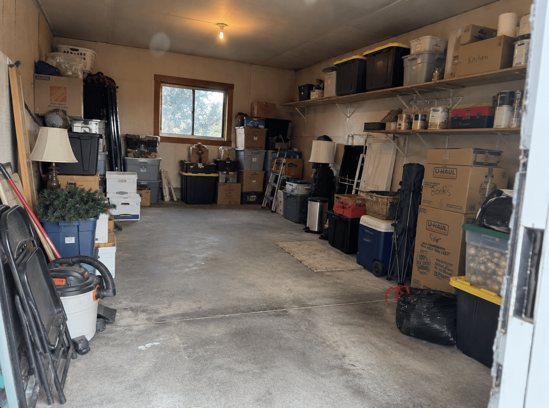 A storage room lined with boxes, bins and loaded shelves